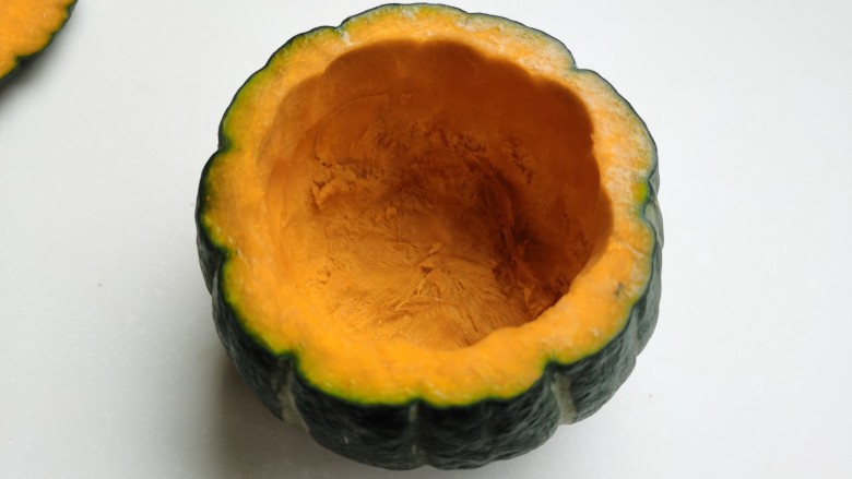 芝士焗南瓜,再把周围的南瓜肉挖一层下来,挖成一个南瓜碗。注意不要把南瓜外皮和底部挖破了。