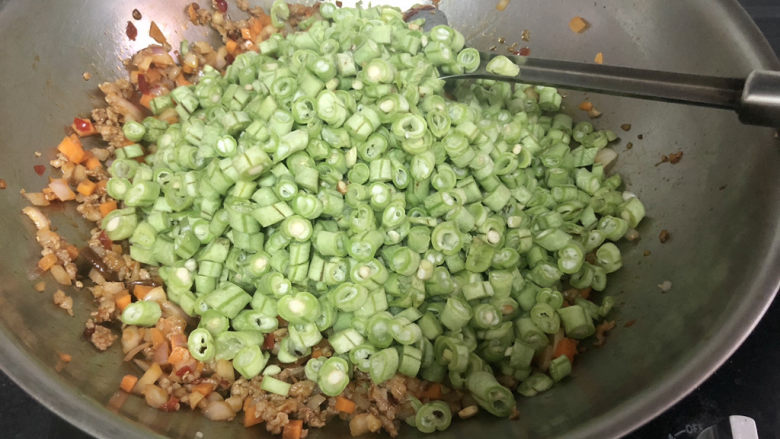 四季豆炒肉,加入四季豆,中火翻炒三分钟,期间可以分次淋少许温水,四季豆一定要炒熟