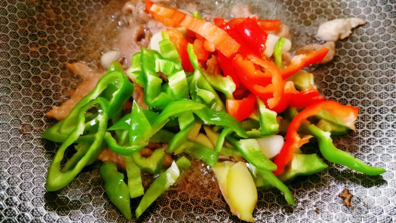 白玉菇炒肉,待肉丝变肉丝炒制变色即可盛出备用,锅里留底油,加入姜蒜青红椒一起翻炒均匀