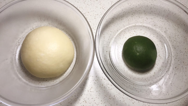 一次发酵的抹茶大理石纹吐司,分割出 120克面团加入抹茶泥,揉至完全融合,分别放两个盆里,松弛十分钟。