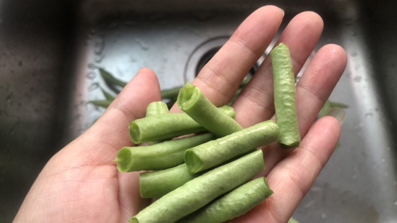 四季豆炒肉,掐去头尾部分,再掐成寸段。