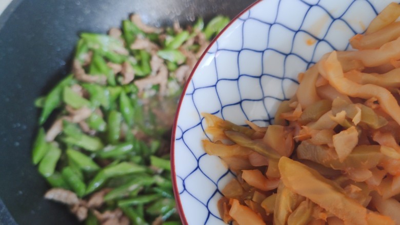 四季豆炒肉,待锅内汤汁差不多收紧,加入榨菜