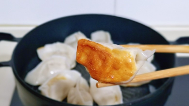冰花锅贴,平底锅中刷少许食用油,摆入包好的饺子,盖上盖子小火慢煎,煎至底部金黄即可。