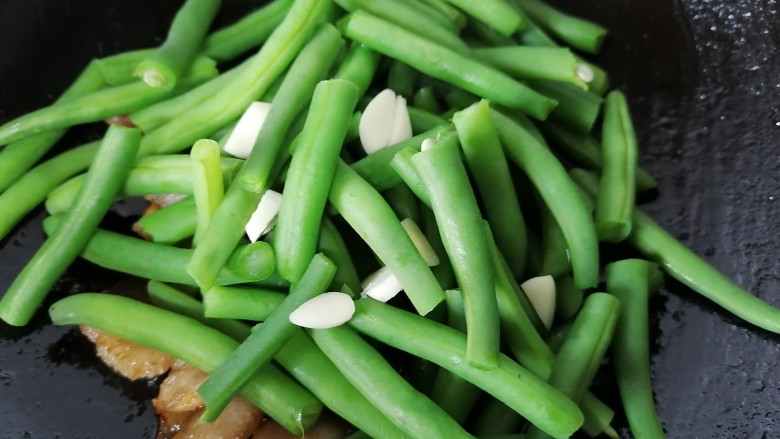 四季豆炒肉,放入四季豆一同翻炒,放入一些蒜片
