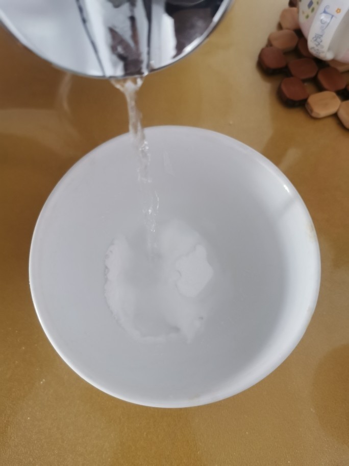 炸油饼,取一个碗,将小苏打用水化开