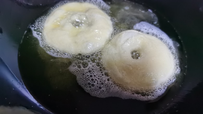 炸油饼,将油饼放入油锅炸制,其间要不停的翻动它。