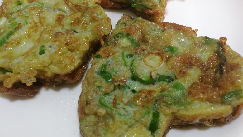 青椒蛋饼,两面煎好后夹出,放入到盘里。They忘了不辣的小辣椒,所以蛋饼很香,遮盖了青椒的那种特殊昧,经常给小朋友吃,可以起到辅助保护视力的作用。