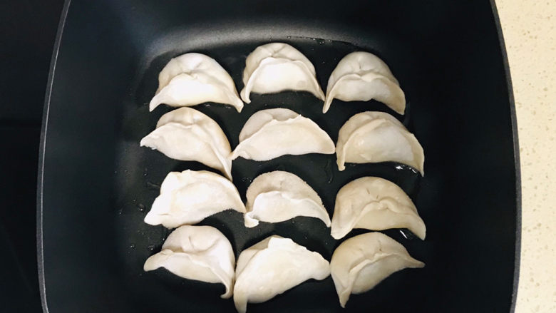 冰花锅贴,将冷冻饺子码放整齐于锅里,饺子不需要化冻