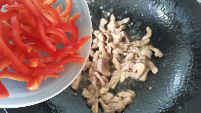 白玉菇炒肉,肉炒至八分熟,倒入红椒丝翻炒片刻