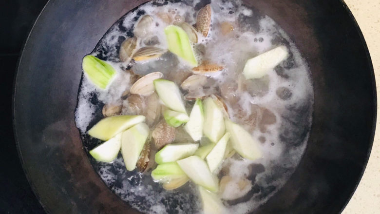 丝瓜花蛤汤,大火煮开后,投入丝瓜,一起煮开