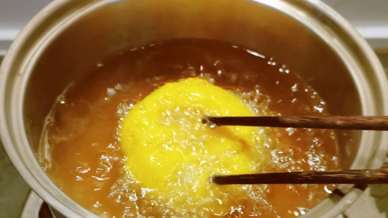 炸油饼,用筷子轻轻敲打 炸制