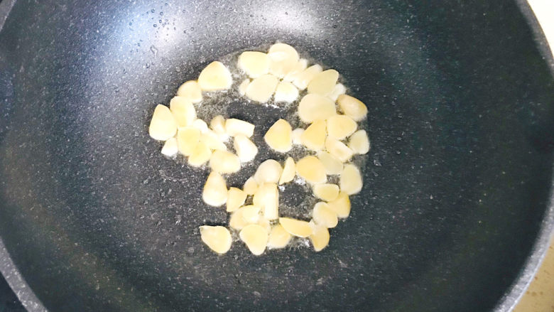 青椒炒素鸡,另起一锅,加油,烧热,投入大蒜瓣煸炒出蒜香