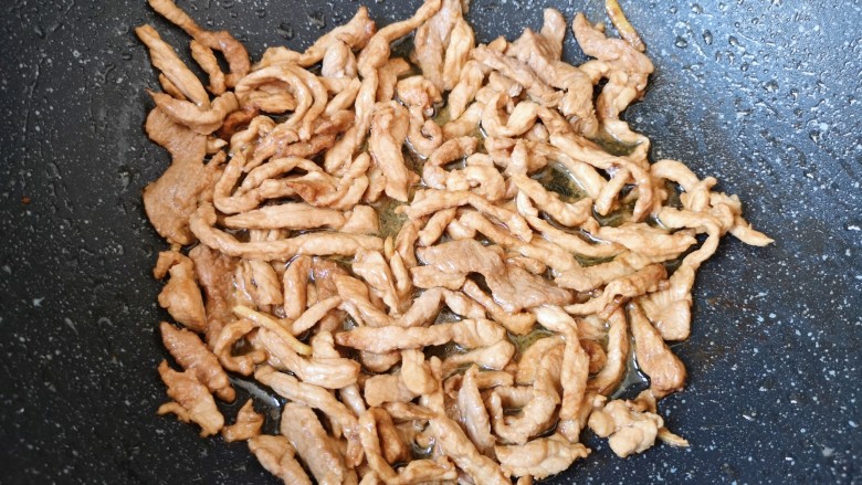 白玉菇炒肉,炒锅内倒适量的食用油烧热,下入腌好的肉丝,炒熟盛出备用。