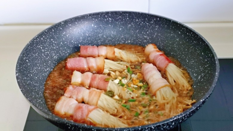 金针菇肥牛卷,倒入调好的酱料汁,加入半小碗纯净水,中火煮2分钟汤汁浓稠即可。