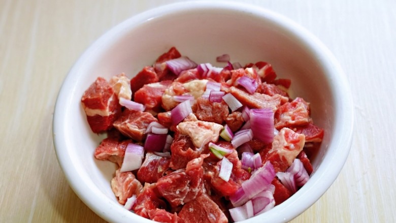 孜然羊肉串,切好的羊肉放入大口器具中,加入切好的<a style='color:red;display:inline-block;' href='/shicai/ 29'>洋葱</a>。