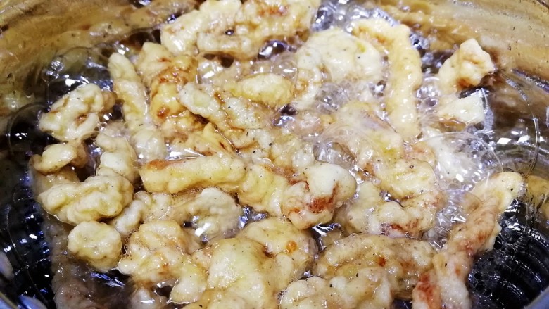 椒盐里脊,油温升高复炸半分钟,改小火侵炸大约2分钟,油花变小,捞出。