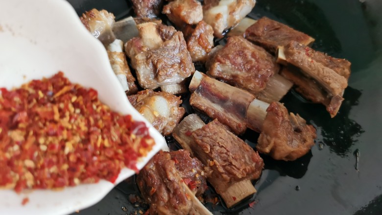 孜然排骨,排骨煎好后,把火调小点,根据个人口味加入适量<a style='color:red;display:inline-block;' href='/shicai/ 761'>辣椒粉</a>。