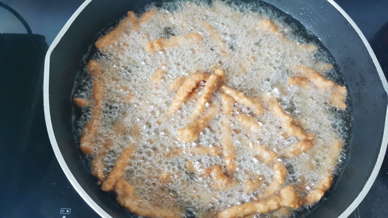 椒盐里脊,待凉一会儿,大火再次烧开放入肉条复炸一下更酥脆