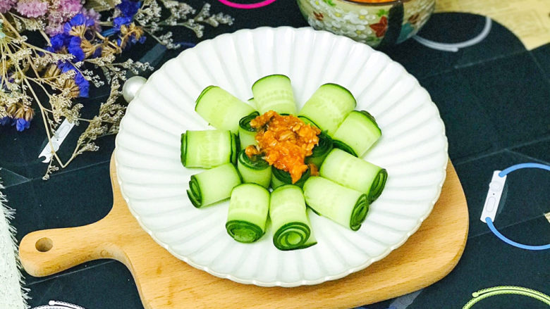 蒜泥黄瓜,在黄瓜花中间浇一勺蒜蓉,吃时拌匀,就是美味的蒜泥黄瓜了