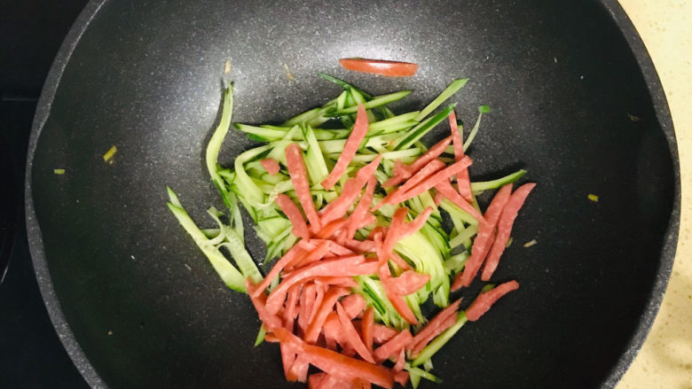 黄瓜炒香肠,投入香肠丝,一起翻炒