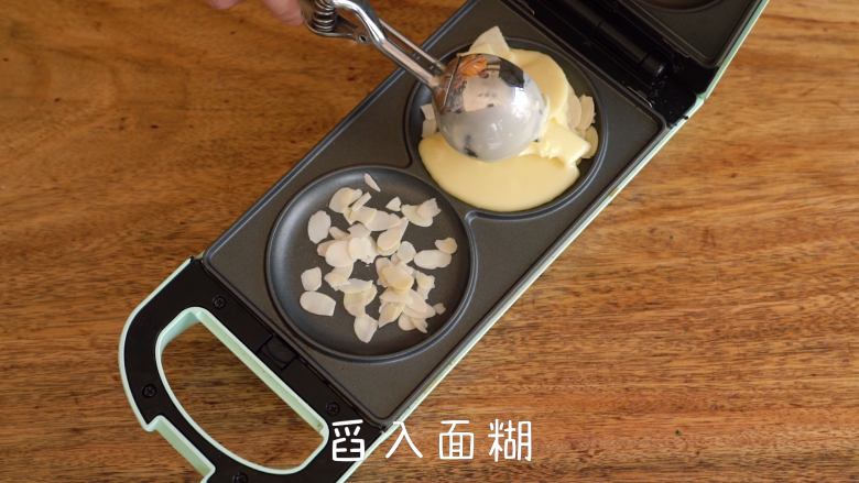 层次分明的苹果千层蛋糕,舀入面糊,再撒上一层杏仁片,盖上上盖,翻转烘烤3分钟