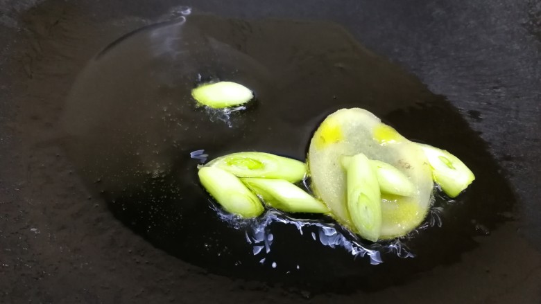 番茄牛腩煲,热锅倒入适量油,倒入葱和姜片炒香。