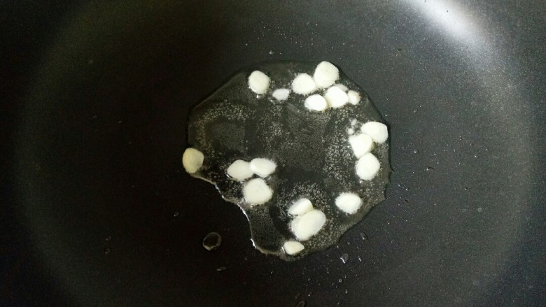 黄瓜炒香肠,炒锅中加入适量油烧热,放入蒜片炒出蒜香味