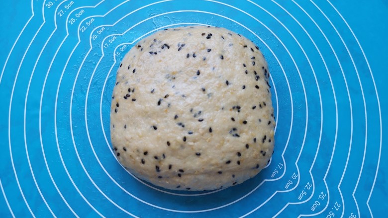 麦片芝麻小餐包,发酵好的面团从面包机里取出,拍打排气。