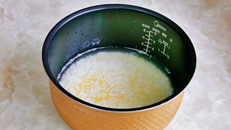 小米蒸排骨,泡好后倒入电饭煲中,水量可以根据个人平时的习惯来加。