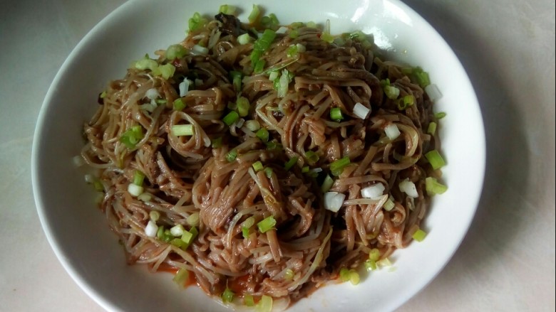 酱香荞麦面拌绿豆芽,盛入盘中，撒上葱花。