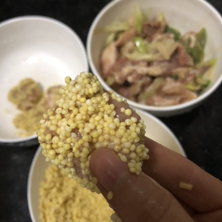 小米蒸排骨,泡好的小米沥干水分,将腌制好的排骨均匀裹上小米