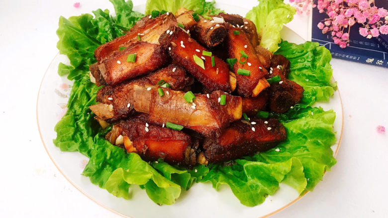 孜然排骨,把排骨摆入生菜上面,撒上葱花和熟白芝麻即可,孜然排骨完成!