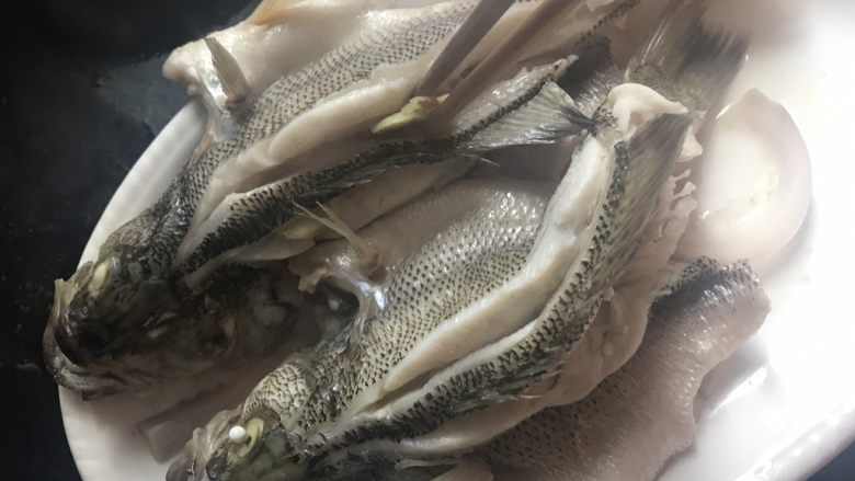 清蒸鲈鱼,蒸好取出来,把姜片挑出来,倒掉蒸汽水