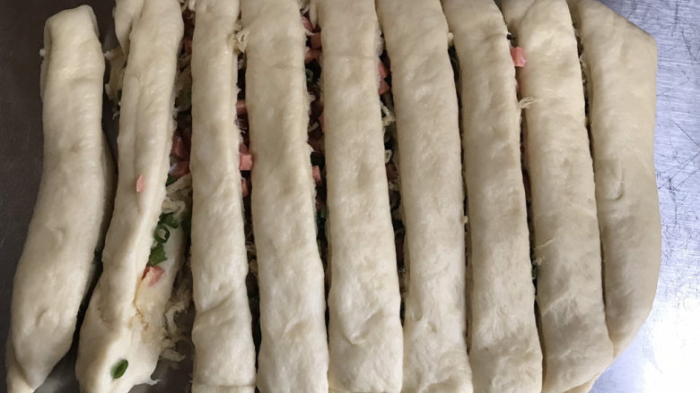 香葱火腿肉松手撕面包,从中间折叠起来,分割成十个左右均等的长条