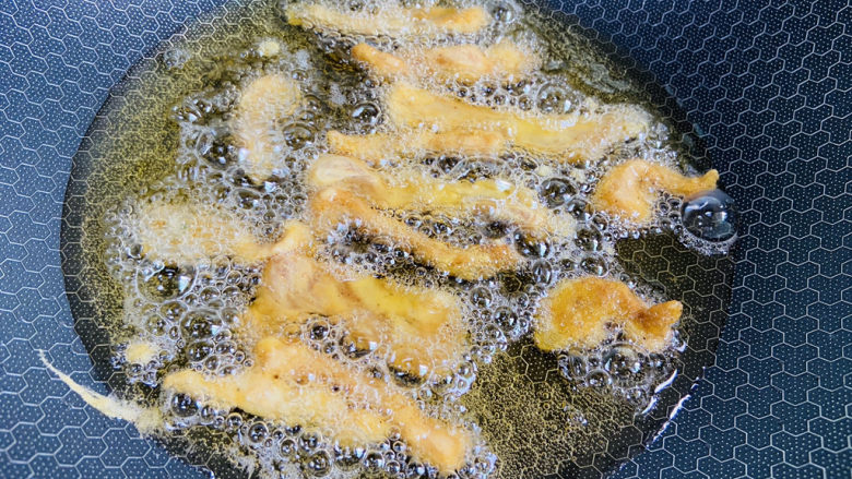 椒盐里脊,锅中加入食用油加热至五成热,将裹好面糊的里脊肉一条一条的放入锅中,开中小火炸三分钟左右