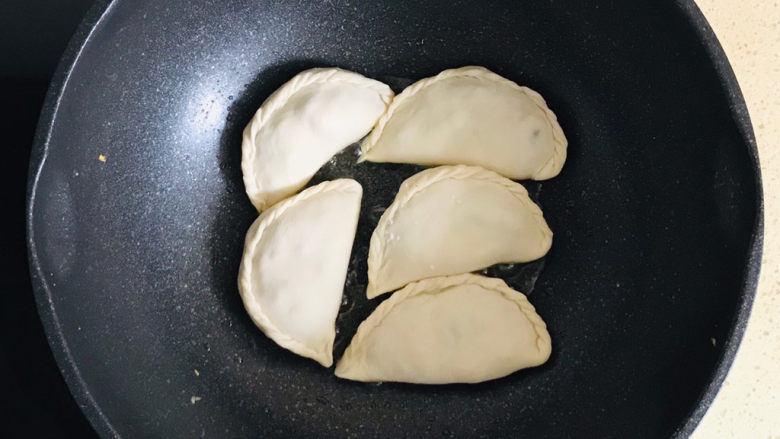 韭菜盒子,不粘锅烧热,淋上橄榄油,将韭菜盒子,码放整齐于锅里