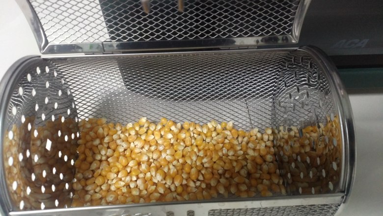 空气炸烤箱爆玉米花,小玉米粒放入烤箱转笼中,扣牢。