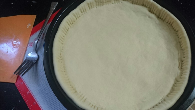 培根火腿披萨,发好的饼皮入模具,用小叉子压紧边缘
