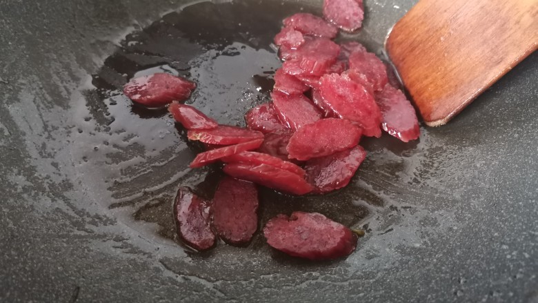 黄瓜炒香肠,倒入香肠,小火翻炒。