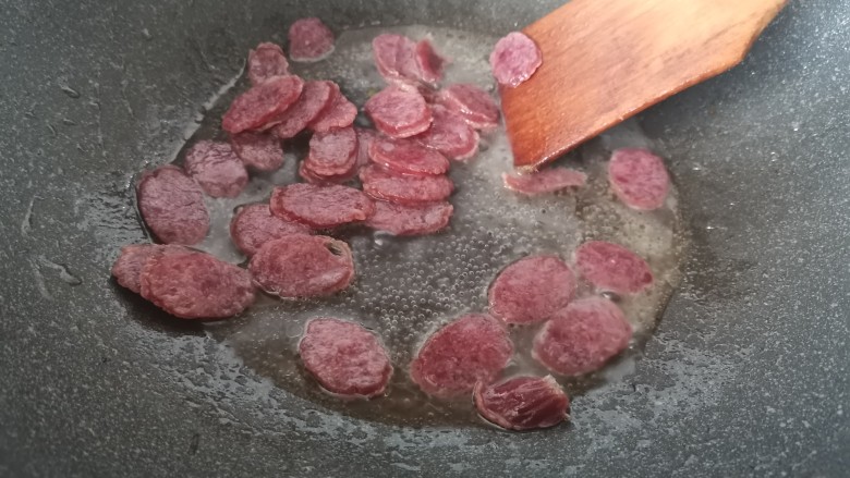 黄瓜炒香肠,加入少许的水,让香肠略煮一下。