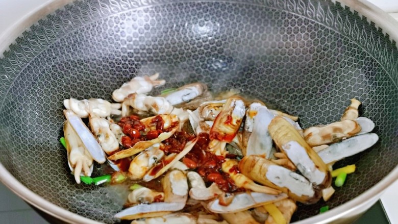 爆炒蛏子,倒入调好的酱料,翻炒均匀。