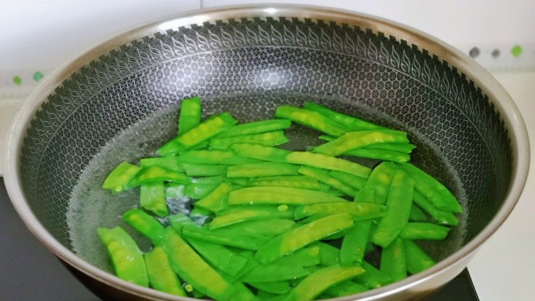 木耳炒山药,荷兰豆焯水,水烧开后下荷兰豆,大火煮30秒捞出过冷水。