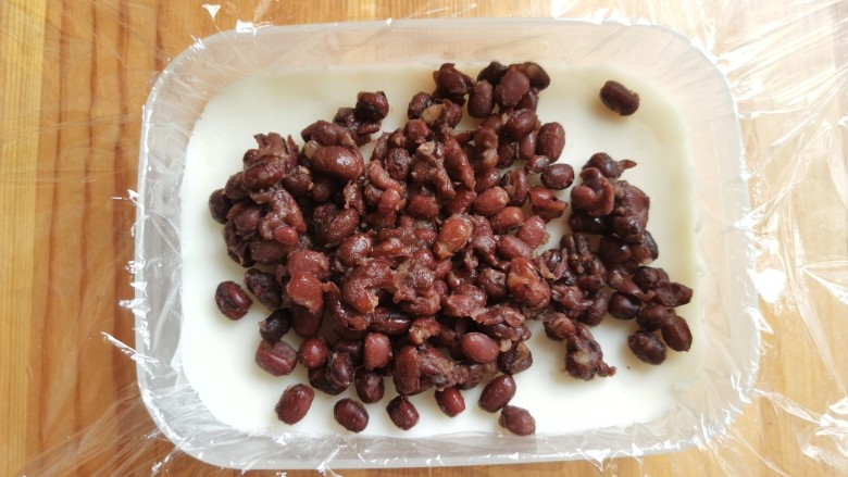 山药红豆糕,上面放上一层红豆,用勺子铺均匀。