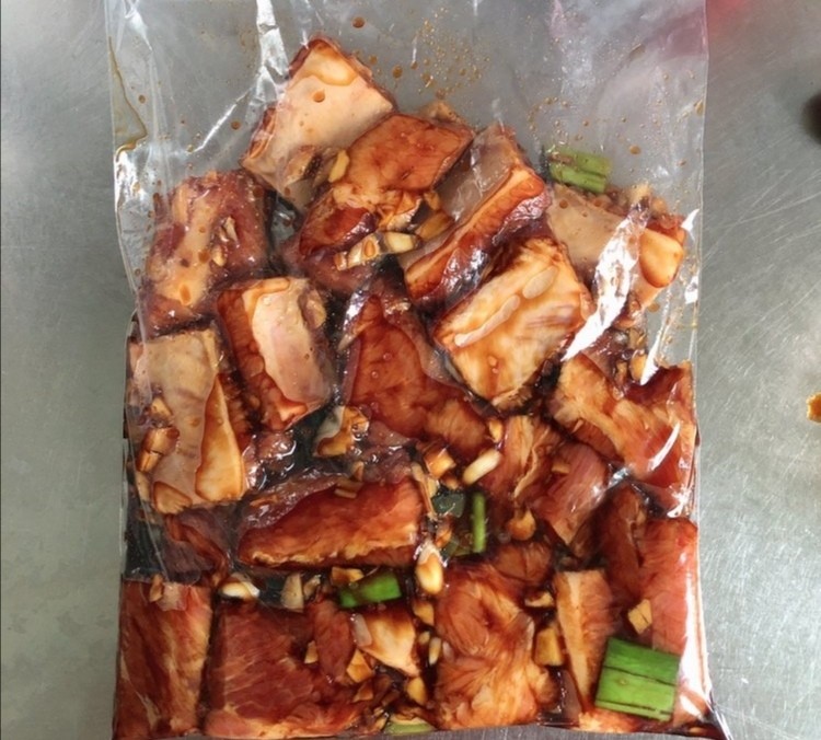 蒜香烤排骨,取封口袋装入排骨,倒入适量调味汁摇匀,每块排骨都沾上汁,放入冰箱冷藏腌制一晚上