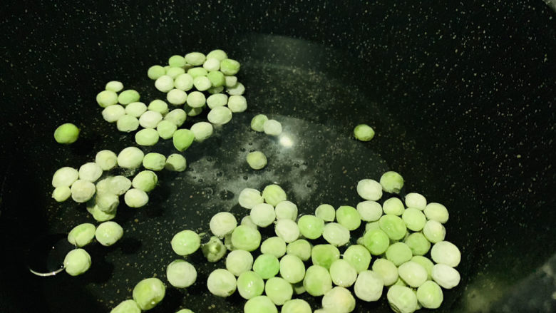 豌豆炒虾仁,另一个锅加清水,加盐加食用油,加入豌豆煮开