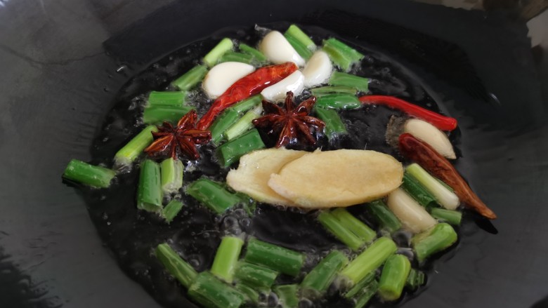 香菇焖鸡,锅里放油,加入葱、姜、蒜、八角、辣椒炒香。