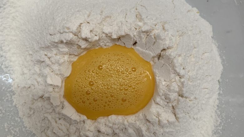 腊肠牛角包,鸡蛋搅均倒入面粉里,留一点刷表面。