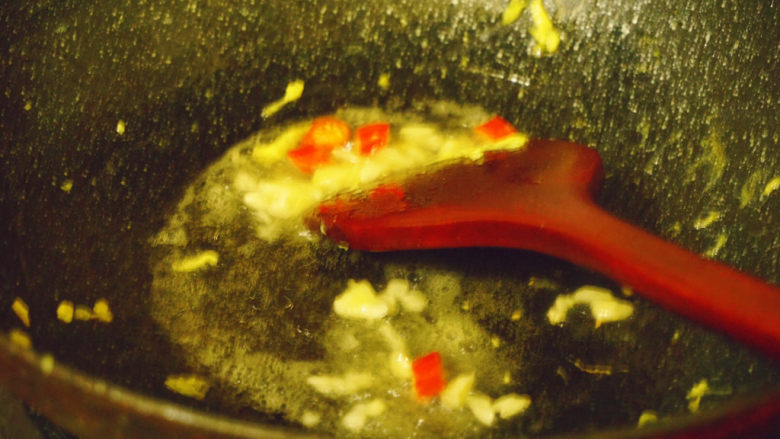 香肠炒蛋,热锅下油,倒入蒜泥和红米椒
