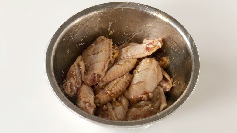 网红薯片鸡翅,不加一滴油也能外脆里嫩又多汁,把鸡翅盖上保鲜膜,放入冰箱冷藏60分钟以上,如果时间允许可以隔上一夜,鸡翅会更入味。