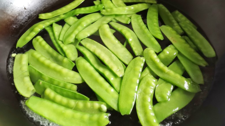 荷兰豆炒菌菇,锅中水开,加一丟丟油和盐,再放入荷兰豆煮1分钟。